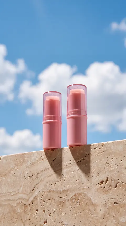 Real Pinnora output: pink lip products standing in sand under a blue sky